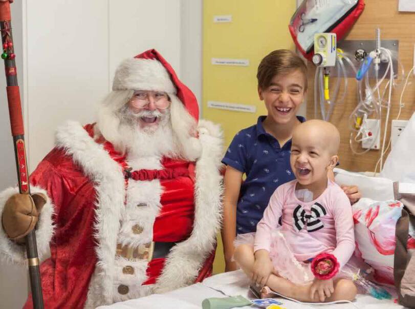 Maddy in hospital with Santa and her brother