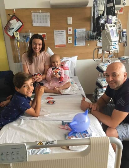 Maddie in hospital playing Uno with her family
