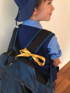 School child with gold ribbon on bag